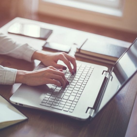 Picture of a person working in home office hand on keyboard close up.